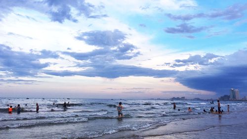 People on beach against sky