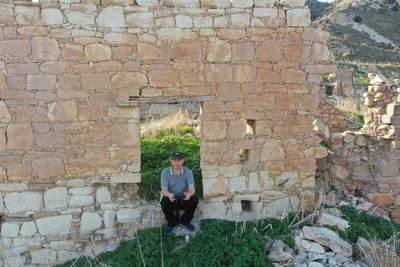 Full length of man standing against brick wall