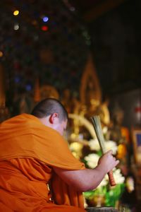 Rear view of man at illuminated temple at night