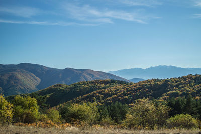 Scenic view of mountains against blue sky