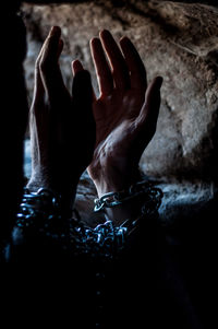 Cropped hand of person tied with chain in prison