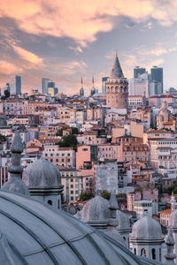 Buildings in city against sky during sunset