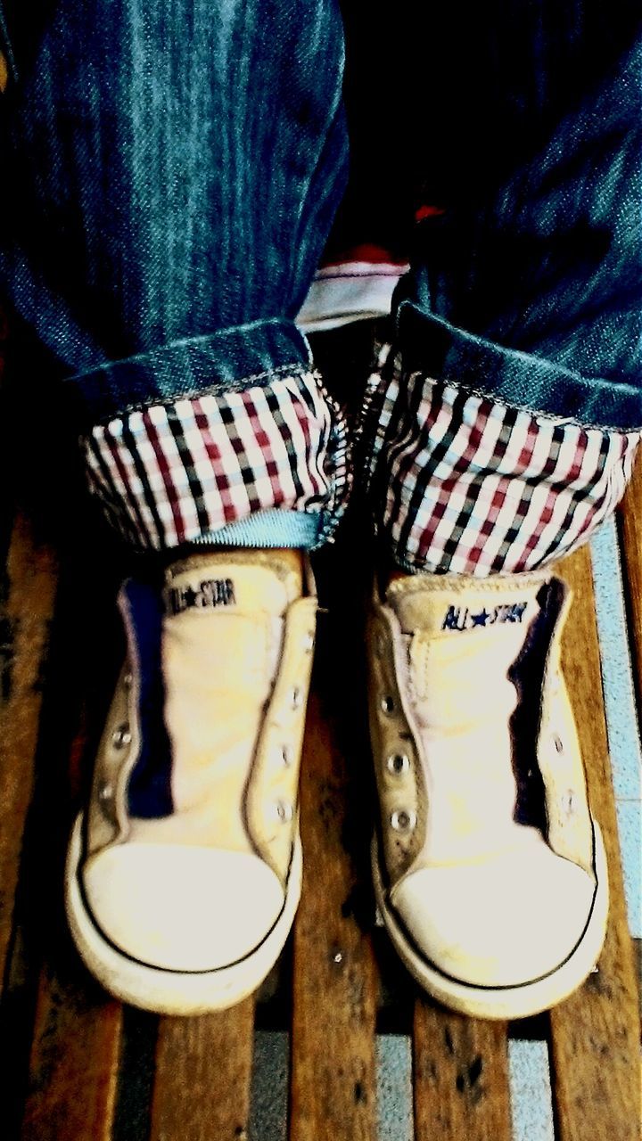 shoe, low section, indoors, person, high angle view, jeans, footwear, canvas shoe, standing, pair, still life, close-up, table, human foot, wood - material, directly above, shoelace, fashion