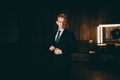 Young man looking down while standing in room