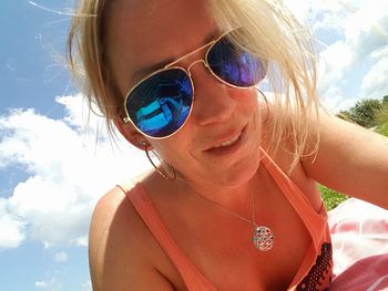 Low angle view of woman wearing sunglasses against sky