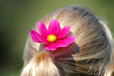 Close-up of woman with pink flower