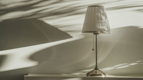 Close-up of electric lamp on bed