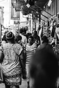 Rear view of people walking on street in city