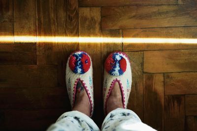 Low section of woman standing on hardwood floor