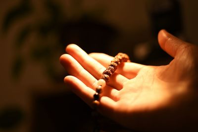 Cropped hand holding prayer beads