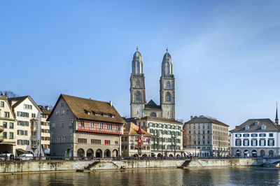 Embankment of limmat river with grossmunster church in zurich, switzerland