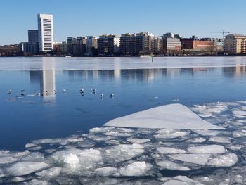 Scenic view of lake and buildings against sky