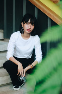 Portrait of young woman sitting outdoors