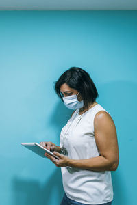 Woman using smart phone against blue background