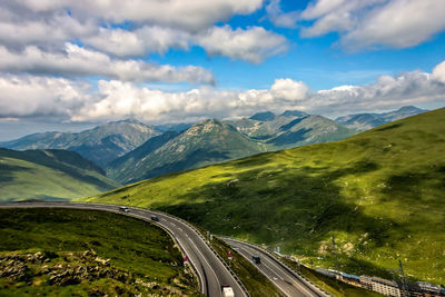 Aerial view of road amidst mountains against sky
