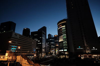 Illuminated buildings against clear sky at night