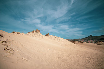 Sand dunes in desert against sky