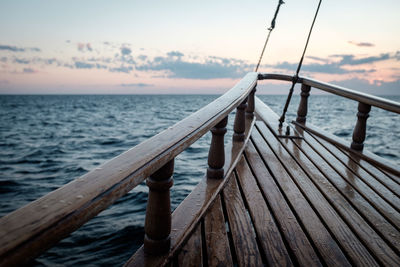 Close-up of wooden railing against sea