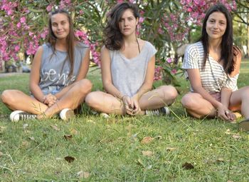 Portrait of happy friends sitting on grass