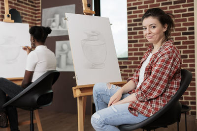 Young woman using laptop while sitting on chair at home