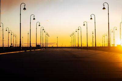 Empty road against sky during sunset