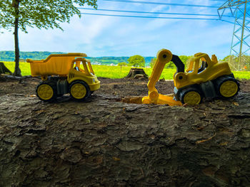 Yellow tractor on field against sky