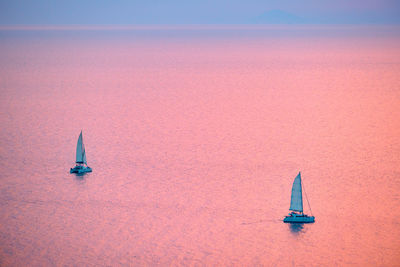 Tourist yachts boat in aegean sea near santorini island watching sunset viewpoint. santorini, greece