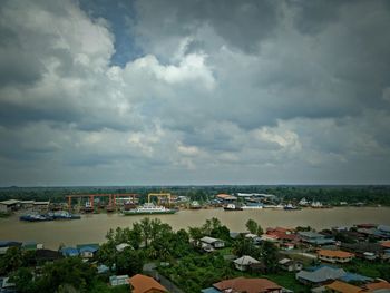 Boats in sea against cloudy sky