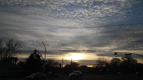 Cars on road against sky during sunset