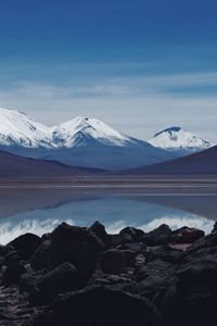 Scenic view of lake by mountains against sky