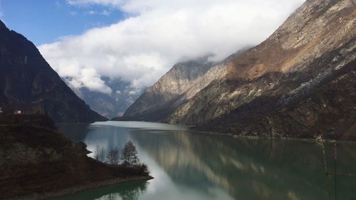 Scenic view of river and mountains against sky