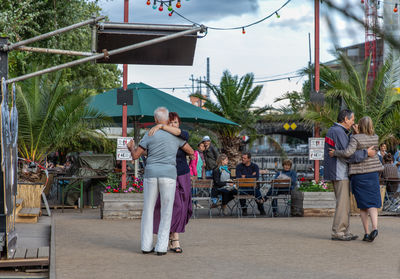 People on sidewalk against plants