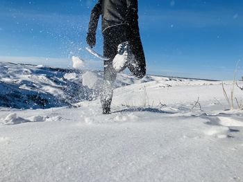 Low section of man running on snow