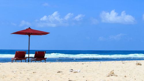 Lifeguard hut on beach against blue sky