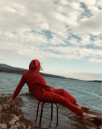 Woman looking at sea against sky