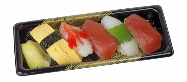 Close-up of sushi served on plate against white background