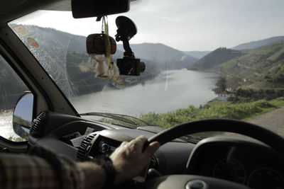 Rear view of man driving car on road