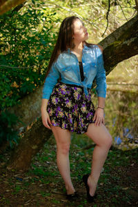 Full length of woman standing against tree