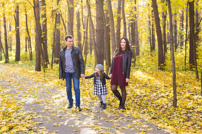 Full length of woman walking in forest during autumn