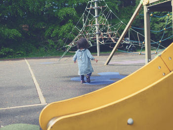 Rear view of baby girl walking at playground