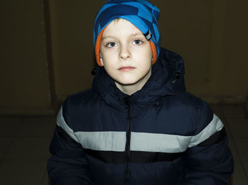 Portrait of boy standing against wall