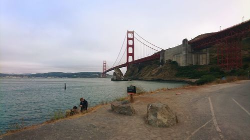 Suspension bridge over water against sky