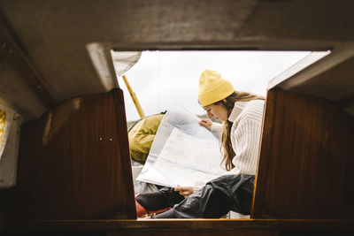 Woman looking at map at entrance to boat cabin