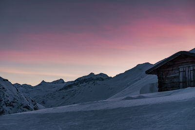 Scenic view of snow covered mountains against sky at sunrise