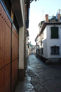 Narrow street amidst buildings against sky