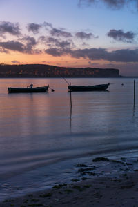 Fishing boats on a river sea at sunset in foz do arelho, portugal