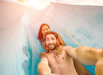 Portrait of smiling young couple in swimming pool