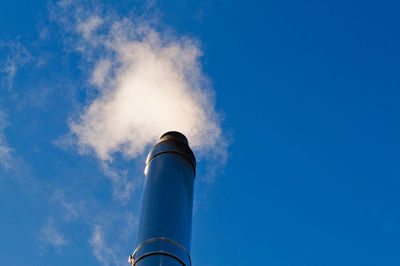 Low angle view of vapor trail against blue sky