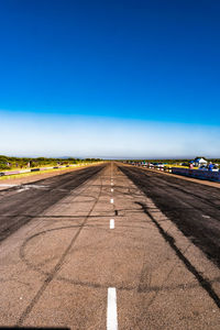 Road against clear blue sky