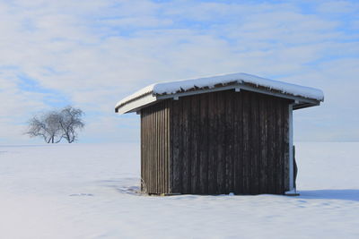 Built structure on snow field against sky